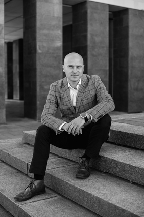 坐在台阶上的黑白光头帅哥写真图片